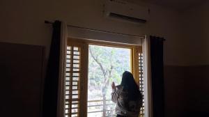 a window in a room with a view of a tree at The Oasis inn in Karnaprayāg