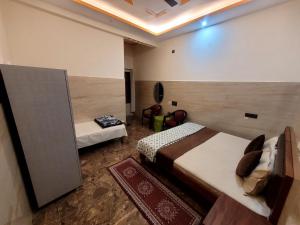 a hotel room with two beds and a chair at The Oasis inn in Karnaprayāg
