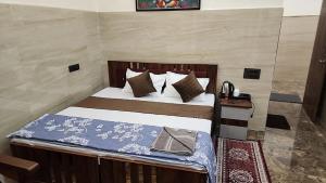 a bedroom with a bed with a blue blanket and pillows at The Oasis inn in Karnaprayāg