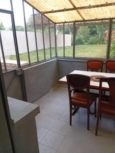 a room with a table and chairs and windows at Tour de bridier in La Souterraine