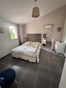 a bedroom with a bed and a chair in it at MAZET en CAMPAGNE in Arles