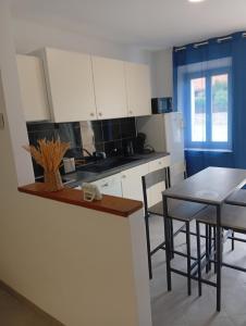 a kitchen with white cabinets and a table with chairs at Tour de bridier in La Souterraine