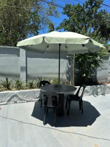 a table and two chairs under an umbrella at Amancio's Tourist Inn-Close to the Airport in Puerto Princesa City +20 photos
