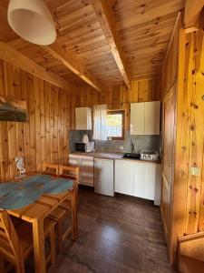 a kitchen with a dining room table and a kitchen with a counter at Promyk in Sarbinowo