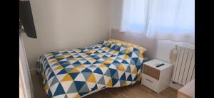 a small bedroom with a bed with a checkered sheet at Mandelieubeach06 in Mandelieu-La Napoule +4 photos