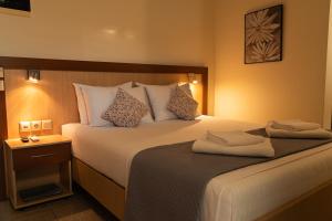 a hotel room with a large bed with two towels on it at Arisvi All Seasons Hotel in Skala Kallonis