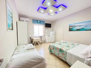 a bedroom with two beds and a table in it at Pensione Affittacamere Miriam in Scalea