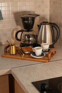 a tray with a coffee pot and cups on a counter at Arisvi All Seasons Hotel in Skala Kallonis +13 photos
