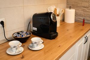 a toaster and two cups on a kitchen counter at Lakuša Retreat in Latin