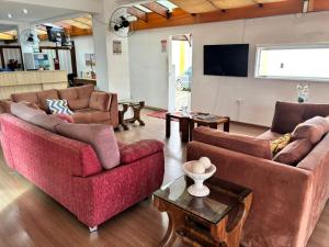 a living room with couches and a flat screen tv at Six's Hotel in Jacareí