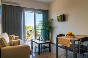 a living room with a couch and a table with fruit on it at Arisvi All Seasons Hotel in Skala Kallonis