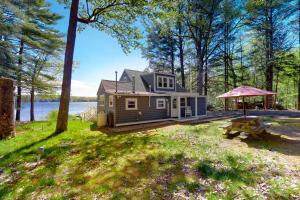 a house in the woods with a picnic table at Highland Playhouse in Windham