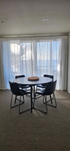 a table and chairs in a room with a window at Waves Kaikoura Waterfront Apartment #1 in Kaikoura +19 photos