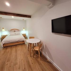 a bedroom with a bed and a table and a tv at Pandanus Studio Lennox Head in Lennox Head