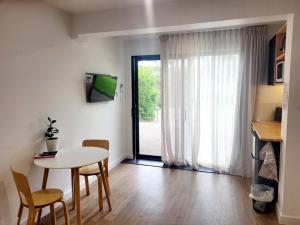 a living room with a table and chairs and a window at Pandanus Studio Lennox Head in Lennox Head