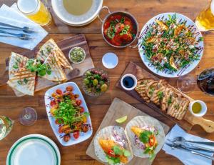 a wooden table with plates of food on it at Pandanus Studio Lennox Head in Lennox Head