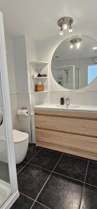 a bathroom with a sink and a toilet and a mirror at Waves Kaikoura Waterfront Apartment #1 in Kaikoura
