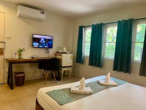 a bedroom with a bed and a desk and a television at UDEE Cozy Hotel in Chiang Mai
