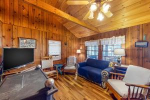 a living room with a blue couch and a pool table at The Red Camp in Casco