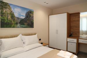 a bedroom with a bed and a painting on the wall at Darius Hotel in Shkodër
