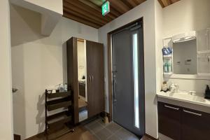 ein Badezimmer mit Waschbecken und Duschtür in der Unterkunft 萩別邸 シーサイド2 HAGI Bettei SEASIDE2 in Hagi