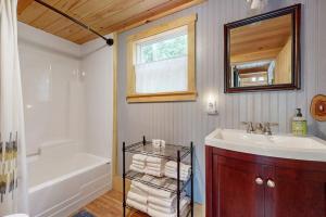 a bathroom with a tub and a sink and a mirror at Loon Cove in Waterville +62 photos