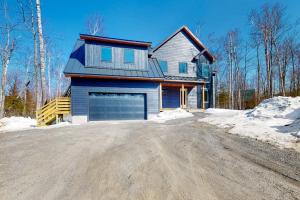 a house with a driveway in the snow at On Mountain Time in Carrabassett