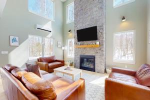 a living room with a couch and a fireplace at On Mountain Time in Carrabassett