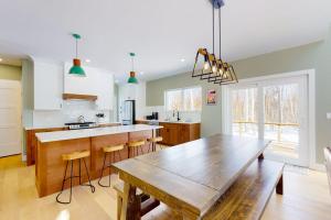 a kitchen with a wooden table and a dining room at On Mountain Time in Carrabassett