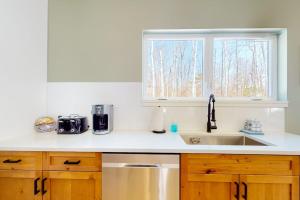 a kitchen counter with a sink and a window at On Mountain Time in Carrabassett +56 photos