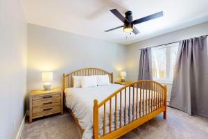 a bedroom with a bed and a ceiling fan at On Mountain Time in Carrabassett