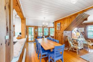 a dining room with a wooden table and blue chairs at Lakefront Retreat in Naples