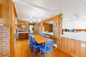 a dining room with a wooden table and blue chairs at Lakefront Retreat in Naples +88 photos