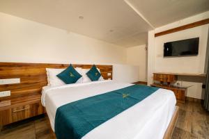 a bedroom with a large bed and a television at The Cloud by Daan in Vagamon
