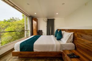 a bedroom with a large bed with a large window at The Cloud by Daan in Vagamon