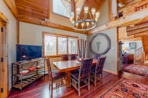 a dining room with a table and chairs and a chandelier at Snow Lion in Carrabassett