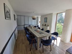 a dining room with a long table and chairs at Ferme du ru paisible in Tournières