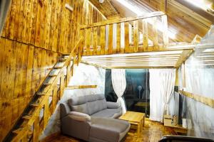 a living room with a couch and a staircase at Sameer Mountain View Cottage in Tanah Rata