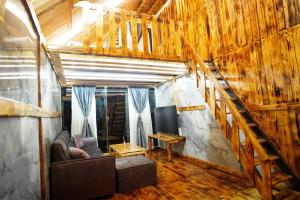 a living room with a couch and a staircase at Sameer Mountain View Cottage in Tanah Rata +1 photo