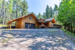 a log home with a garage in the woods at Northwoods Dream Retreat in Whitefish