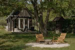two chairs and a table in front of a house at A Házikó in Balatonederics