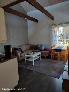 a living room with a couch and a table at Holisko in Ylläsjärvi