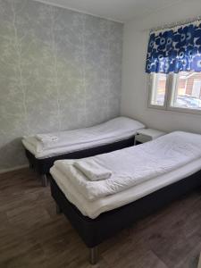 a room with two beds and a window at Home nest in Seinäjoki