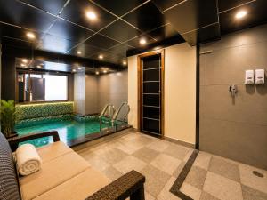 a swimming pool in a room with a couch and a table at The Moksh DA Hotel A Premium Property Near Jaypee Hotel in Mussoorie
