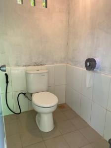 a bathroom with a white toilet in a room at The Green Pearl Paradise in Biluhu