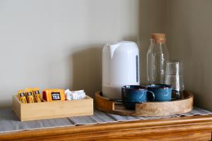 a coffee maker and cups on a wooden shelf at St Michaels Reach Guest House in Marazion