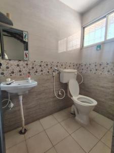 a bathroom with a toilet and a sink at Outbackwoods homestay room Robusta in Vastāra
