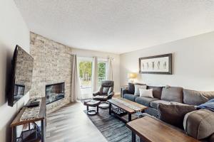 a living room with a couch and a fireplace at Big Horn 3 in Big Sky