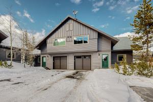 a gray house with green doors in the snow at Big Horn 18 in Big Sky