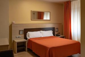 a hotel room with a bed with an orange blanket at Hotel SPA GBC Avenida Pontevedra in Pontevedra